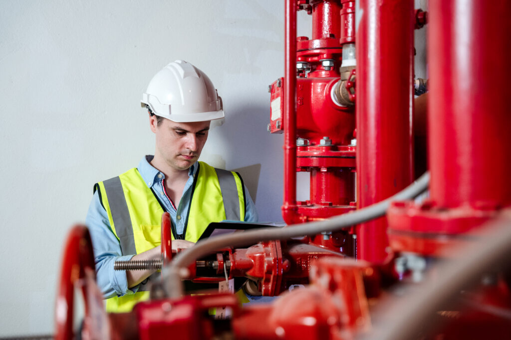 Man performing inspection of fire suppression pipes and equipment